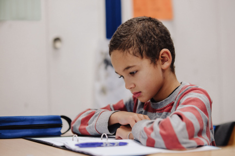 Un enfant fait ses devoirs à l'école. 
