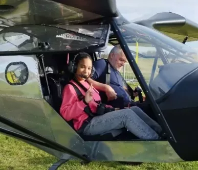 Jeune fille souriante dans un ULM