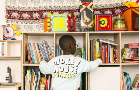 Un enfant choisi un livre dans une bibliothèque