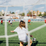 Des enfants jouent au football dans un city stade. 