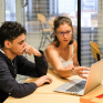 Une éducatrice accompagne un jeune dans l'utilisation d'outils informatiques