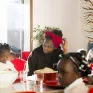 Des mamans sont atour d'une table et partagent un bon moment avec leurs enfants.